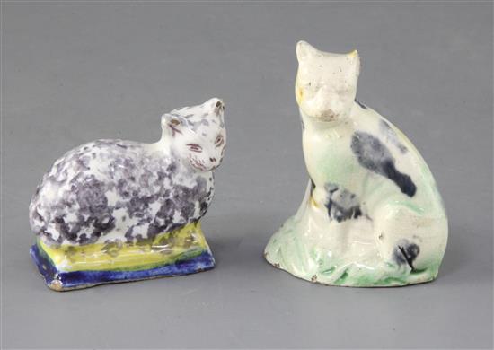 A Whieldon type creamware figure of a cat, c.1780 and a tinglaze figure cat on a cushion, possibly 18th century, tallest 8cm